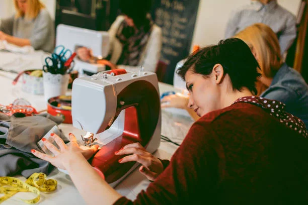 Women sitting by the sewing machine and learning sewing on sewing class Women sitting by the sewing machine and learning sewing on sewing class